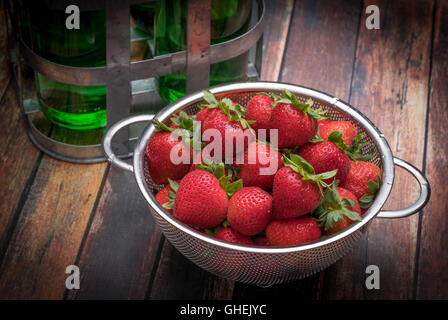 Frische Erdbeeren in Edelstahl Sieb auf eine Holzoberfläche Stockfoto