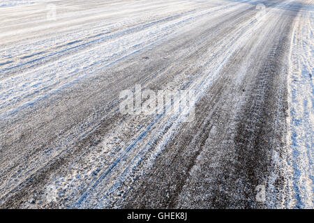 Vereister Fahrbahn. Reifen Spuren hinterlassen in Schnee und Eis auf der Straße im Winter, England, Großbritannien Stockfoto