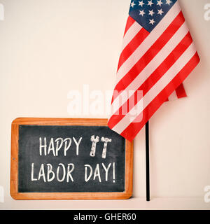 ein aus Holz gerahmt Tafel mit dem Text glücklich Arbeitstag geschrieben und eine Flagge der Vereinigten Staaten gegen eine wollweiße bac Stockfoto