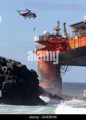 Ein Hubschrauber der Küstenwache Winden eine Bergung Experten an Bord der Transocean-Gewinner Bohranlage, nachdem es bei schweren Wetterbedingungen vor der Küste der Isle of Lewis lief Stockfoto