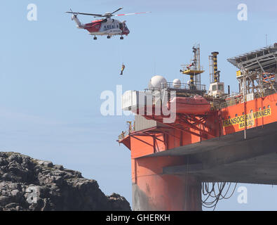 Ein Hubschrauber der Küstenwache Winden eine Bergung Experten an Bord der Transocean-Gewinner Bohranlage, nachdem es bei schweren Wetterbedingungen vor der Küste der Isle of Lewis lief Stockfoto