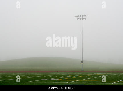 Stadion-Leuchten auf einem Fußballplatz an einem geheimnisvollen, nebligen Tag in Chicago, Illinois Stockfoto