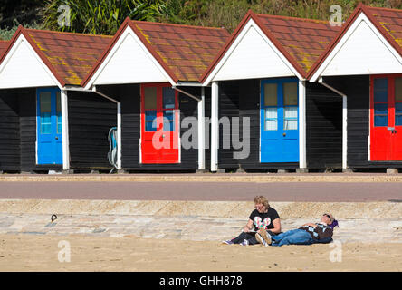 Bournemouth, Dorset, UK. 28. September 2016. Paar mit Strandhütten hinter an einem herrlich warmen sonnigen Tag am Strand entspannen. Bildnachweis: Carolyn Jenkins/Alamy Live-Nachrichten Stockfoto