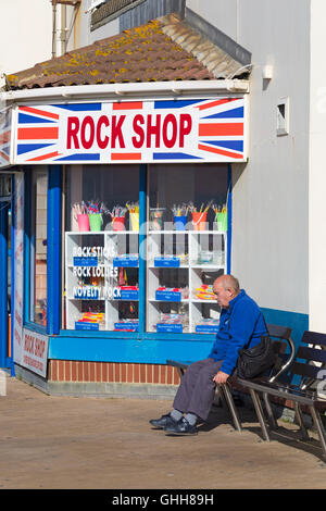 Bournemouth, Dorset, UK. 28. September 2016. Mann sitzt auf der Bank außerhalb der Rock Shop am Eingang zum Bournemouth Pier an einem herrlich warmen sonnigen Tag. Bildnachweis: Carolyn Jenkins/Alamy Live-Nachrichten Stockfoto