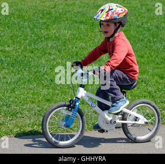 Ein vier Jahre alter Junge, der sein Fahrrad Stockfoto