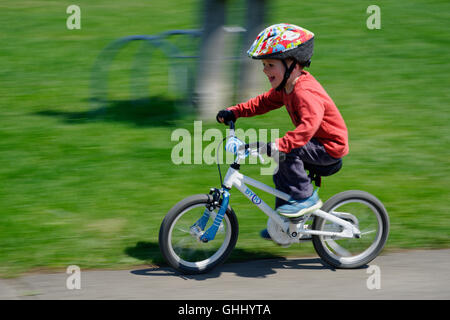 Ein vier Jahre alter Junge, der sein Fahrrad Stockfoto