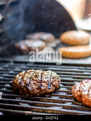 Heißes frisches Rindfleisch Hamburger auf Grill und Brot Stockfoto