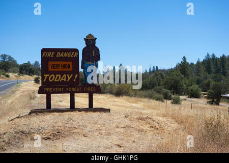 Sehr hohes Risiko von Feuer Warnzeichen auf der Straße mit Abbildung der Yogi Bär. In der Nähe von Yosemite-Nationalpark.  Kalifornien. USA Stockfoto