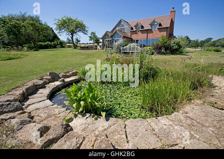 Wilde Gartenteich mit Lilien und andere Wasserpflanzen im unteren Garten Colemans Hill Farm Ökohaus Mickleton UK Stockfoto