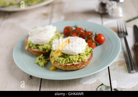 Avocado auf Toast mit pochierten Eiern und Tomaten Stockfoto