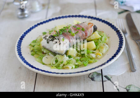 Schellfisch mit Kartoffeln und Lauch in Pancetta umwickelt. Stockfoto