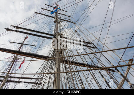 Muster des Segelns Schiffe Masten, Arbeitsbühnen und Seile gegen ein bewölkter Himmel Stockfoto