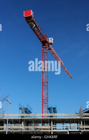 Baustelle mit rotem Kran über einen klaren blauen Himmel. Stockfoto
