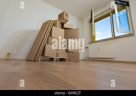 Umzug in eine neue Wohnung, Boxen in einem leeren Raum Stockfoto