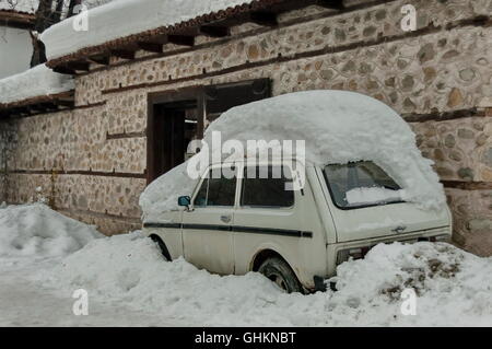 Schneeverfrachtung Abdeckung vorne und Auto im Winter in Bansko, Bulgarien Stockfoto