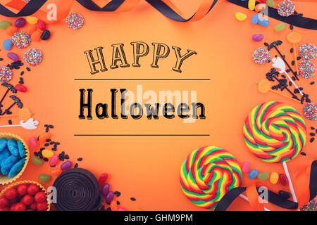 Halloween Süßigkeiten begünstigt auf einem hellen orange Hintergrund mit verzierten Rahmen und Textfreiraum, mit Filter und Happy hinzugefügt Stockfoto