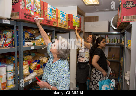Freiwillige Helfer Lager Regale bei North Paddington Tafel Stockfoto