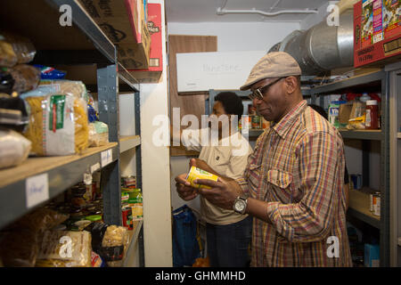 Freiwillige Strumpf ein Regal im Norden Paddington Tafel. Stockfoto