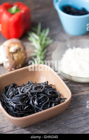 Zutaten für schwarze Nudeln mit Pilzen und Gemüse Stockfoto