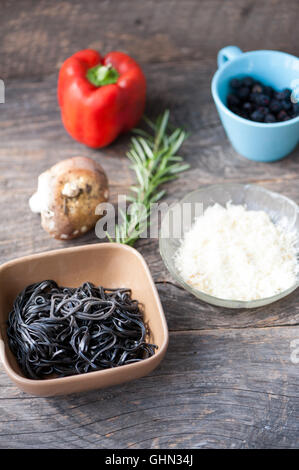 Zutaten für schwarze Nudeln mit Pilzen und Gemüse Stockfoto