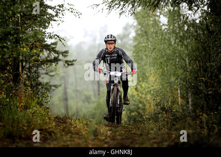 junger Mann Athlet Radfahrer fährt durch Wald bei regionalen Wettkämpfen auf cross-country-bike Stockfoto