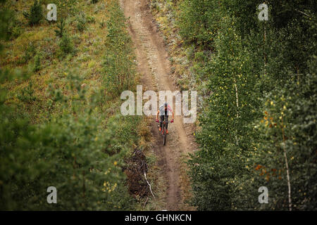 Übersichtsplan-Fahrer ein Radsportler, die auf einem Waldweg bei regionalen Wettkämpfen auf Langlauf Fahrrad Stockfoto