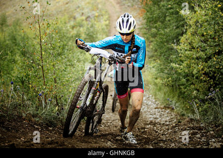 junges Mädchen Mountainbiker Berg zu Fuß mit ihren Bikes während der Regionalwettbewerbe auf Langlauf Fahrrad steigen Stockfoto