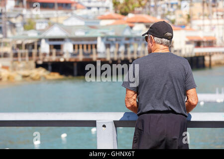 Ältere Mann steht auf dem grünen Vergnügen Pier In Avalon, Catalina Island, Kalifornien. Stockfoto