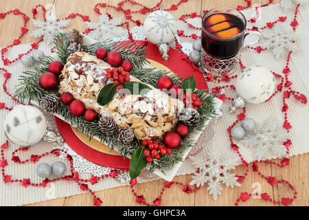 Weihnachtsstollen Christstollen, Glühwein cocktail, Holly, Tanne, rot, Silber und weiß Tand Dekorationen mit Glitzer Schneeflocken. Stockfoto