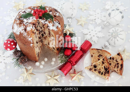 Schokolade Panettone Weihnachtskuchen und Scheibe mit Beeren der Stechpalme, Cracker, rot, Silber, gold und weißen Schneeflocke, Runde und Sterne Stockfoto