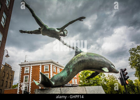 Junge mit einer Dolphin-Bronzeskulptur von David Wynne vor dem Mercedes-Benz Showroom in Chelsea, London, England, Großbritannien Stockfoto