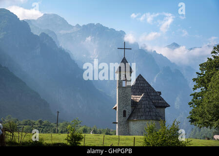 Die Schindel überdacht Kirche an das Dorf von Theth mit der albanischen Alpen im Hintergrund, Nordalbanien. Stockfoto