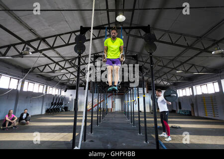 Mann tut Gym Übung an den Ringen im Fitness-Studio Stockfoto