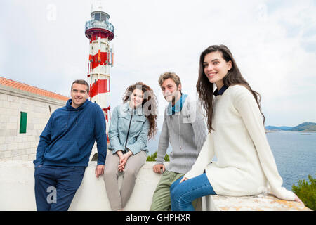 Gruppe von Freunden mit Leuchtturm im Hintergrund Stockfoto