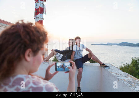 Junge Frau, die eine Aufnahme von Freunden am Meer Stockfoto