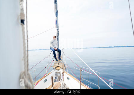 Mann sitzt am Bug der Yacht Tagträumen Stockfoto