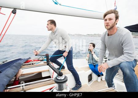 Mann, die Wicklung Seil mit Seilwinde auf yacht Stockfoto