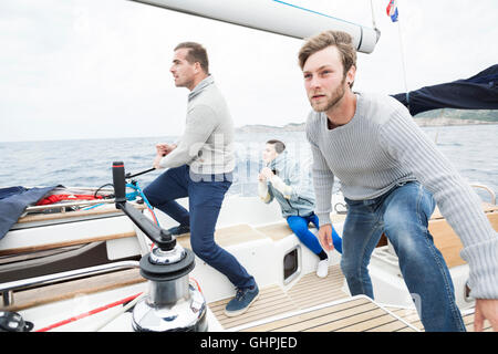 Mann, die Wicklung Seil mit Seilwinde auf yacht Stockfoto