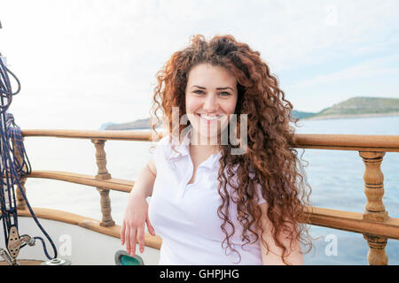 Portrait der schönen Frau mit lockigem Haar auf Segelboot Stockfoto