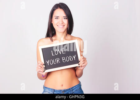 Junge Frau mit Tafel, die Love Your Body liest. Selbstliebe-Konzept. Stockfoto