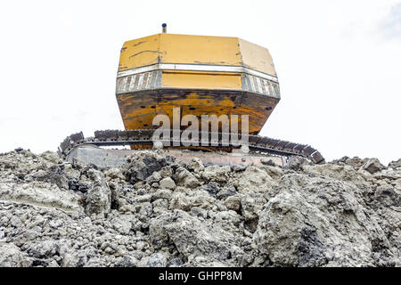 Gelbe Bagger macht Flor des Bodens durch Hochziehen Boden auf Heap auf Baustelle, Projekt im Gange. Stockfoto