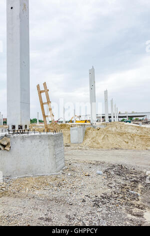 Arbeiter dienen Holzleiter auf Baustelle. Verstärkte die Stäbe sind aus dem Betonpfeiler, Basis für neue hervorstehenden Stockfoto