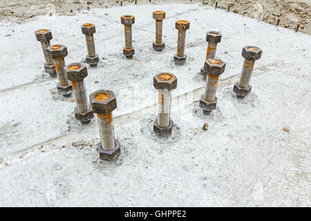 Die Ankerschrauben in Betonsockel des neuen Gebäudes mit Verstärkung an Baustelle hautnah. Stockfoto