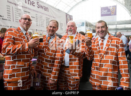 4 Männer trinken Bier in passende "Ziegelstein" Stil Anzügen auf dem Great British Beer Festival in Olympia, West London Stockfoto