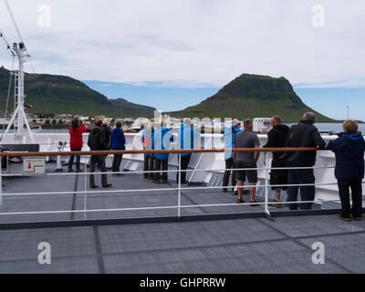 Passagiere im Bogen des Kreuzfahrtschiffes beobachten Annäherung an kleine Fischergemeinde Grundarfjörður Stadt auf Snæfellsnes Halbinsel Island und Kirkjufell Stockfoto