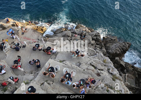 Draufsicht Personen Buza, ein Freiluft-Café und eine Bar auf den Klippen in Dubrovnik, Kroatien. Stockfoto