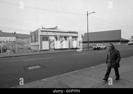 Ein Mann zu Fuß außerhalb der Kakadu Public House, Pollockshaws in der Southside von Glasgow 1991. Stockfoto