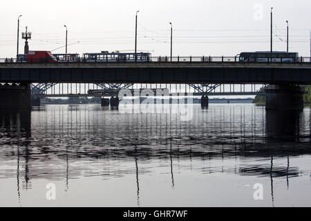 Die Silhouette der Brücke befindet sich gegen den schönen Himmel mit kleinen Wölkchen. Dies ist ein Sonnenuntergang in Riga - europäische Stadt. Stockfoto