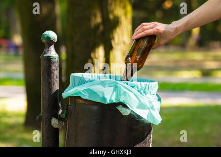 Hand der Frau Glasflasche in alten Müll werfen können, Konzept von Abfall und Umwelt Schutz Stockfoto