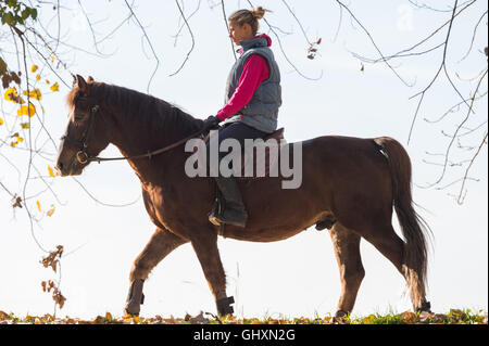 Junges Mädchen reiten durch den Wald Stockfoto